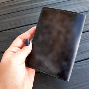 May include: A black leather passport holder with the text "Remarkable" embossed on the front.