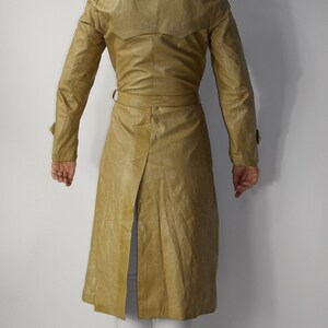 May include: A long, tan leather trench coat with a belt and a single back vent.