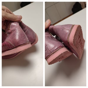 May include: A pair of pink leather boots with a pink rubber sole. The boots are worn and have a distressed look.
