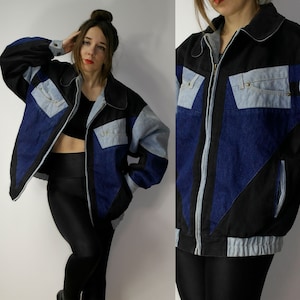 Peut inclure: Une veste en jean bleu et noir avec une fermeture éclair. La veste a un design géométrique en patchwork avec différentes nuances de jean bleu.