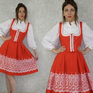 May include: A red and white dress with a white lace bodice and a red skirt with white embroidery. The skirt has a scalloped hem.