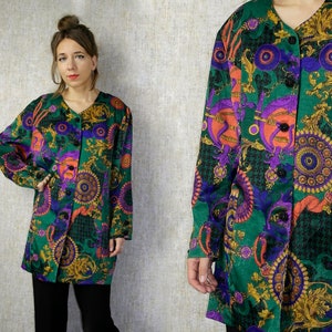May include: A long-sleeved button-up shirt with a green background and a colorful, abstract pattern. The pattern features circles, swirls, and floral motifs in shades of purple, orange, red, and gold.