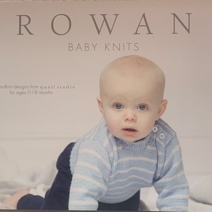 Puede incluir: Un libro titulado "Rowan Baby Knits" con un bebé que lleva un suéter de punto azul y blanco a rayas. La portada del libro incluye el texto "11 handknit designs from quail studio for ages 0-18 months."