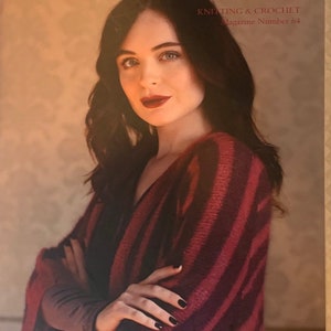 May include: A woman wearing a red and black striped knit cardigan with a magazine cover that reads "ROWAN KNITTING & CROCHET Magazine Number 64"