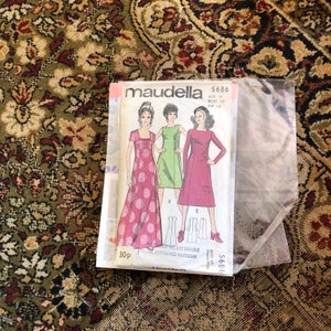 Könnte beinhalten: Vintage-Nähmuster-Umschlag für ein Kleid, mit drei Models, die verschiedene Kleidstyles tragen. Das Muster ist für Größe 16, Brustumfang 96,5 cm und Hüftumfang 101,6 cm. Der Umschlag ist mit "Maudella 5686" beschriftet.