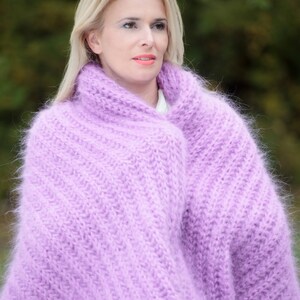 Peut inclure: Une femme portant un ch&acirc;le en mohair tricot&eacute; doux et de couleur lilas clair. Le ch&acirc;le est drap&eacute; autour de ses &eacute;paules et de son cou, cr&eacute;ant un look confortable et &eacute;l&eacute;gant.