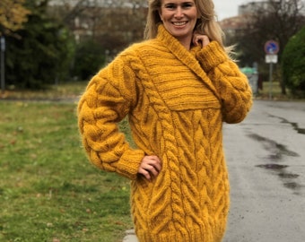 May include: A long, yellow, cable knit sweater with a collared neckline.