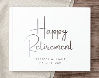May include: White hardcover guest book with silver foil lettering that reads "Happy Retirement" and "Rebecca Williams March 8, 2024".