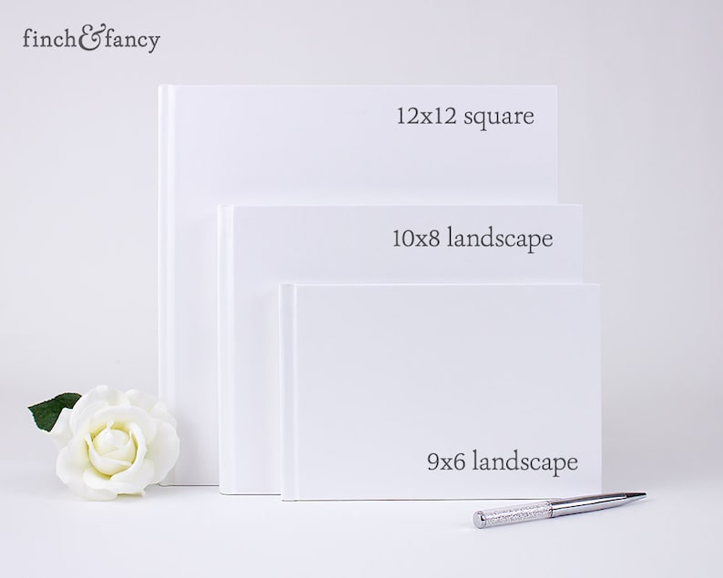 May include: Three white photo albums of different sizes. The largest album is 12x12 inches square, the middle album is 10x8 inches landscape, and the smallest album is 9x6 inches landscape.