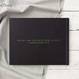 May include: Black hardcover journal with gold lettering on the front. The text reads "LET ALL THAT YOU DO BE DONE IN LOVE." 1 Corinthians 16:14
