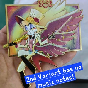 May include: A colorful enamel pin featuring a cartoon character with a top hat, wings, and a violin. The character is dressed in a white suit with a pink vest and black pants. The pin has a gold border and the text "2nd Variant has no music notes!"