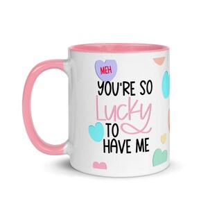 Lustige Keramik-Kaffeetasse „Lucky To Have Me“ mit Herzen und Farbe im Inneren