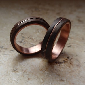 May include: Two wooden rings with copper inlay. The rings are stacked on top of each other.