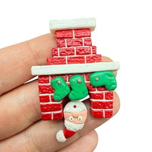 Broche/alfinete vintage da Hallmark, década de 1980, em plástico rígido, com Papai Noel e meias pendurados.