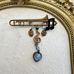 Vintage Trombone Brooch with Dangling Charms masquerade Blue Heart