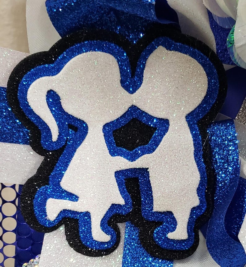 May include: A white glitter cutout of two people holding hands, outlined in black and blue glitter. The cutout is on a white background with blue glitter.