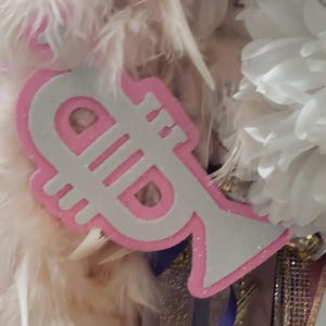 May include: A white and pink trumpet-shaped party decoration with glitter.