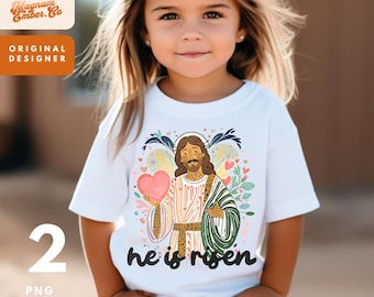 May include: A white t-shirt with a colorful illustration of Jesus holding a heart and the text "he is risen".