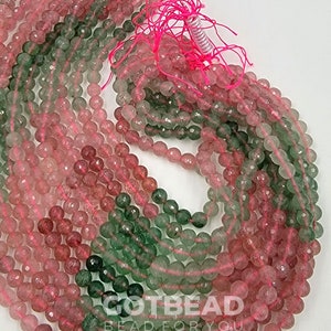 Peut inclure: Un brin de perles de pierres pr&eacute;cieuses vertes et roses. Les perles sont rondes et ont une finition facet&eacute;e. Les perles sont enfil&eacute;es sur un cordon &eacute;lastique transparent.