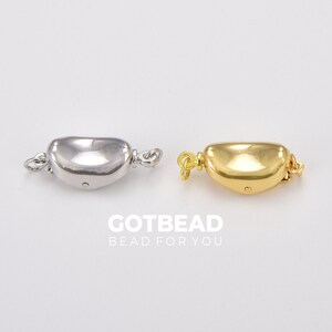 以下が含まれることがあります： ネックレスまたはブレスレット用のシルバーとゴールドの留め具2個。留め具は半円形で、滑らかで光沢のある仕上げになっています。