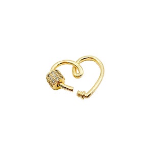 May include: Gold heart-shaped clasp with a clear crystal-encrusted barrel. This clasp is a jewelry finding for making necklaces, bracelets, and other jewelry.