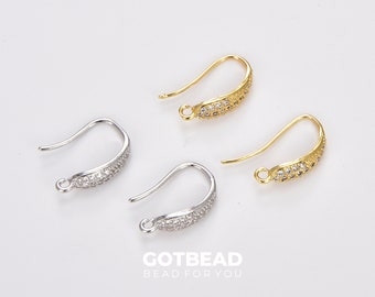 May include: Three pairs of earring hooks with a silver and gold finish. Each hook is decorated with a row of clear rhinestones.