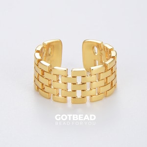 May include: Gold-toned ring with a woven design. The ring is open and adjustable.