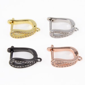 May include: Four earring hooks with a curved design and a row of clear rhinestones. The hooks are available in gold, silver, black, and rose gold.