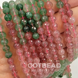Peut inclure: Un brin de perles rondes facett&eacute;es dans des tons de vert et de rose. Les perles sont translucides et ont un aspect mouchet&eacute;. Les perles sont enfil&eacute;es sur un fil rose fin.