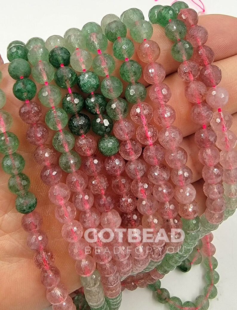 Peut inclure: Un brin de perles rondes facett&eacute;es dans des tons de vert et de rose. Les perles sont translucides et ont un aspect mouchet&eacute;. Les perles sont enfil&eacute;es sur un fil rose fin.