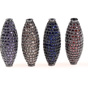 May include: Four oval-shaped beads with a black metal finish and a faceted design. The beads are in shades of purple, brown, blue, and red.
