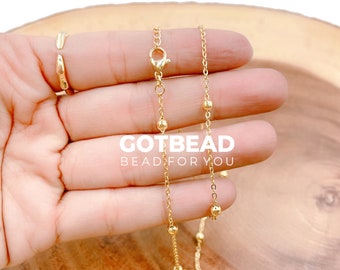 May include: A gold chain necklace with small round beads. The chain is delicate and has a lobster clasp closure. The necklace is approximately 18 inches long.
