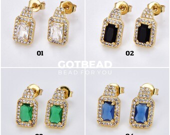 May include: Four pairs of gold earrings with different colored stones. The earrings have a square-shaped stone surrounded by smaller stones. The stones are white, black, green, and blue.