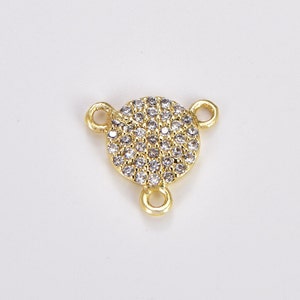 May include: Gold-tone connector with three loops and a round, pave-set crystal centerpiece.