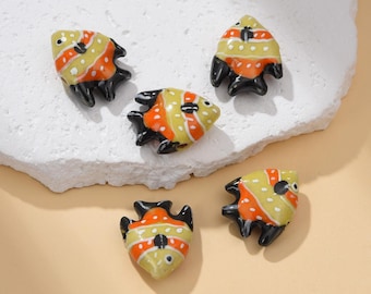 May include: Five small, decorative fish figurines. Each fish has a yellow body with orange stripes and black fins. The figurines are arranged on a white, textured surface. The number "#01" is in the upper right corner.