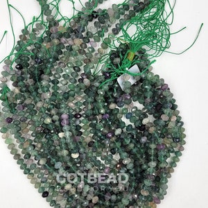 May include: A strand of green, faceted fluorite beads. The beads are approximately 4mm in size and have a slightly irregular shape. The beads are strung on a green thread and are ready to be used in jewelry making.