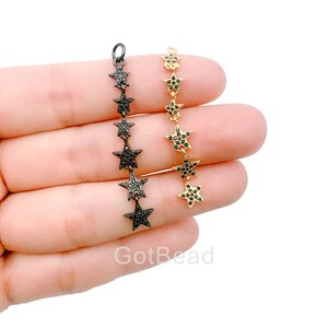May include: Two star-shaped chains with black cubic zirconia stones. One chain is gold-toned and the other is black-toned.