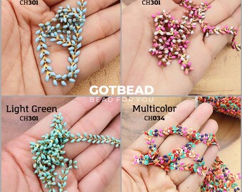 May include: Four different colors of gold chain with small leaf-shaped beads. The colors are light blue, two-tone, light green, and multicolor. The chain is labeled with the color and a code number.