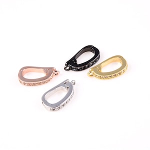 May include: Four different colored metal clasps with clear crystal embellishments. The clasps are in silver, gold, rose gold, and black.