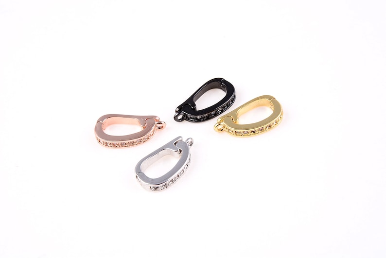 May include: Four different colored metal clasps with clear crystal embellishments. The clasps are in silver, gold, rose gold, and black.