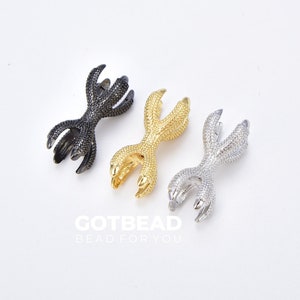 May include: Three metal claw charms in black, gold, and silver, arranged on a white surface. The charms are detailed with textured surfaces and sharp talons. The text "GOTBEAD BEAD FOR YOU" is at the bottom.