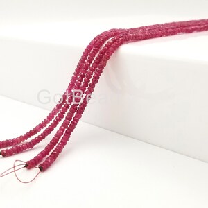 May include: Four strands of ruby red faceted gemstone beads strung on wire. The beads are small and uniform in size.