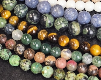 May include: A selection of round, polished gemstone beads in a range of colours, including green, blue, brown, and pink. The beads are arranged in rows, with the largest beads at the top and the smallest beads at the bottom.