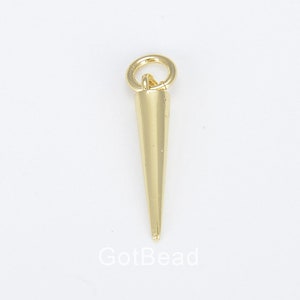 May include: Gold-toned metal spike charm with a loop at the top. The spike is long and pointed.