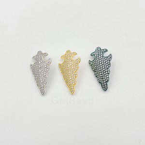 May include: Three silver, gold, and black metal pendants with a leaf-like design, each covered in small clear rhinestones.