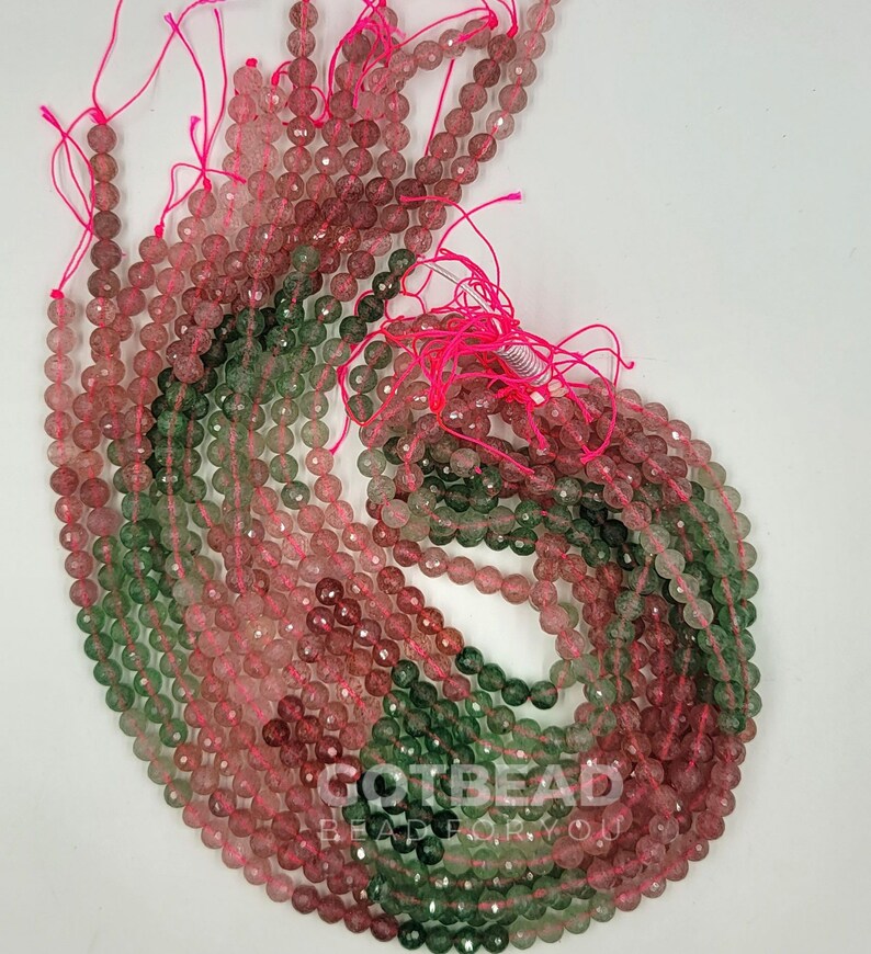 Peut inclure: Un brin de perles facett&eacute;es de couleur verte et rose. Les perles mesurent environ 6 mm de diam&egrave;tre et sont enfil&eacute;es sur un cordon &eacute;lastique rose.