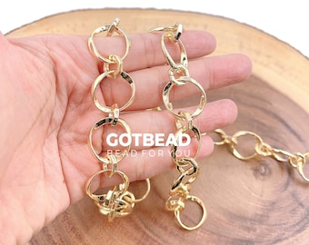 May include: Gold-colored chain links with a mix of round and elongated shapes. The chain is held in a hand, with the text "GOTBEAD BEAD FOR YOU" visible. The links are shiny and appear to be made of metal.
