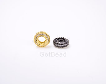 May include: Two round spacers for jewelry making, one gold and one black, both with clear crystal accents.