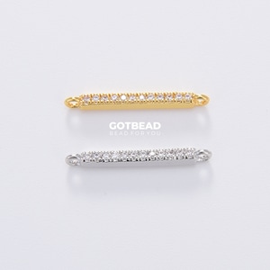 May include: Two bar connectors with clear crystal accents. The top connector is gold and the bottom connector is silver.