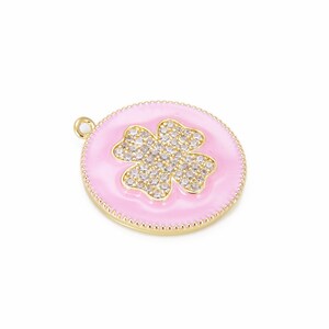 May include: A gold-tone pendant with a pink enamel background and a four-leaf clover design set with clear rhinestones.